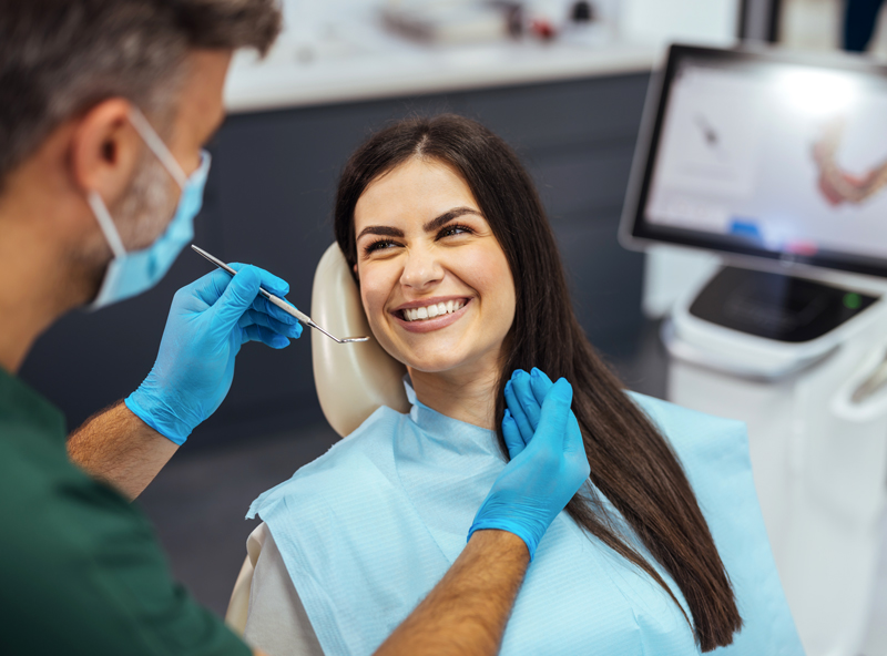 Dentist-examining-patient's-teeth-in-clinic Dentist Examining a Patients teeth
